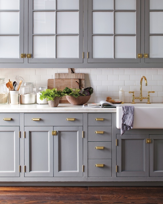 Brass hardware on grey kitchen cabinets. Image via Martha Stewart.