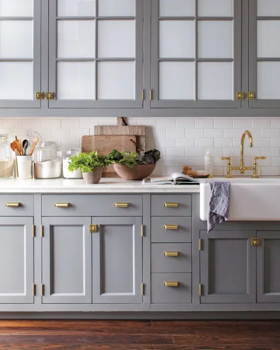 Brass hardware on grey kitchen cabinets. Image via Martha Stewart.