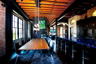 Contemporary loft with blue countertops with pendent lighting over the island and dining table 