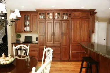 Staggered and stacked Cherry cabinetry with mullion doors and paneled appliances