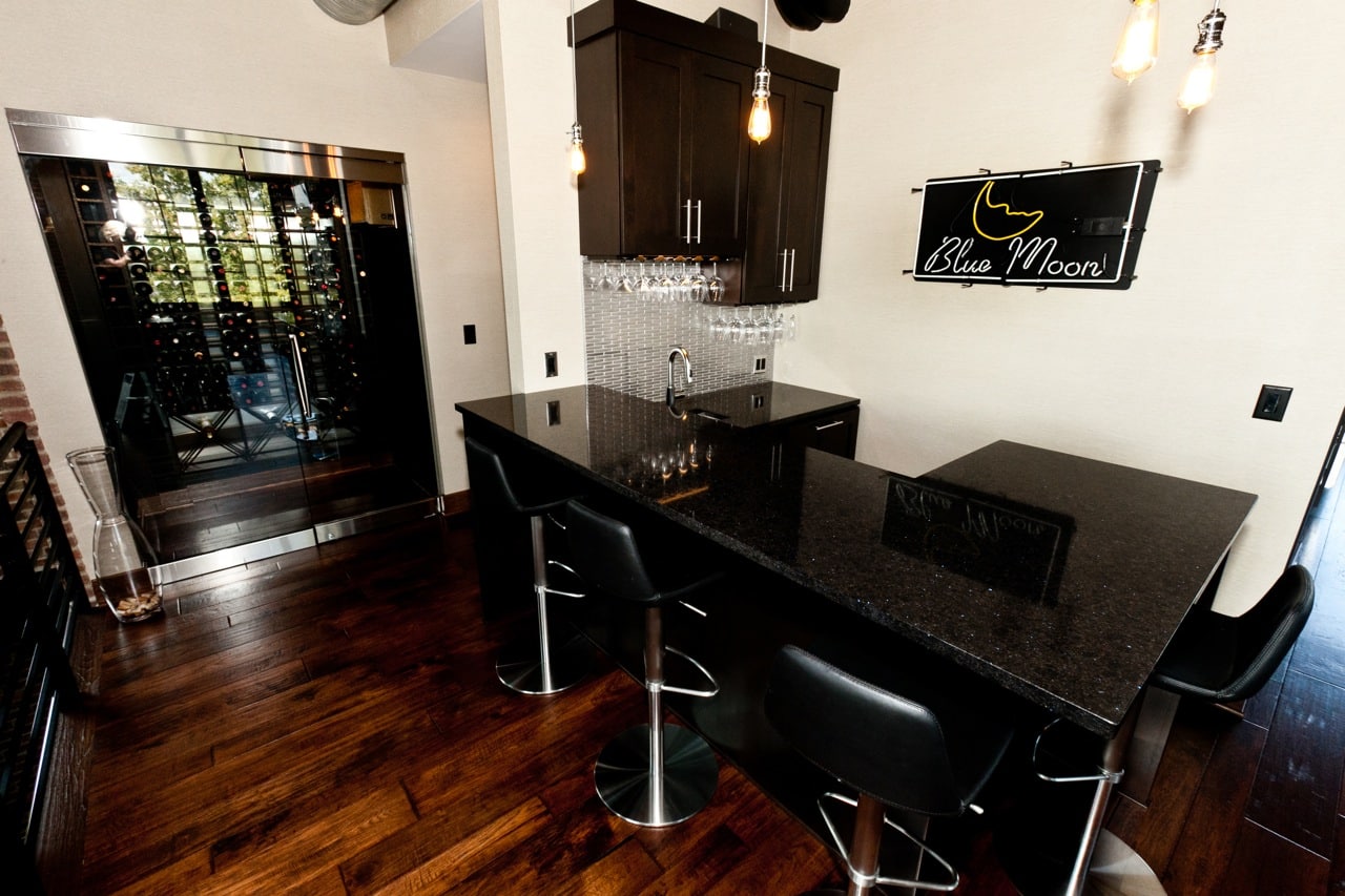 Contemporary bar with espresso cabinets and black granite and pendent lighting 