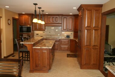 Tiered island with pendent lighting and decorative wood range hood