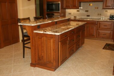 Two Tiered island with cherry wood cabinetry with integrated end panels