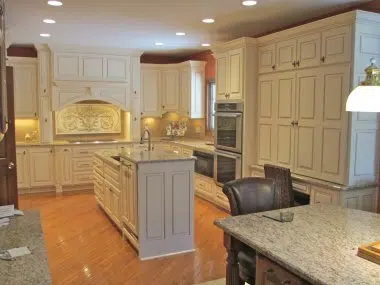 Traditional cream cabinets with glaze accent and arched valance over the cooktop