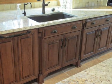 Cherry cabinetry with decorative sink base with onlays and wood paneled dishwasher 