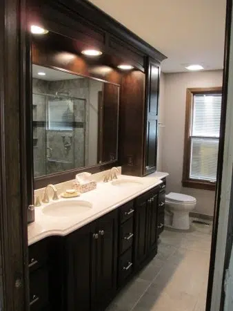 Traditional master bath with dark cabinetry and bumped out cabinets