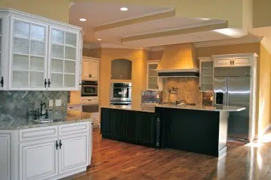 Black and white kitchen with painted wood range hood and hardwood flooring 