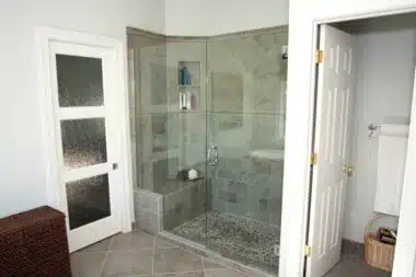 Open top, walk-in glass enclosed shower with pebble floor