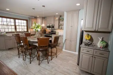 Taupe cabinetry brightens up the use to be dark traditional kitchen 