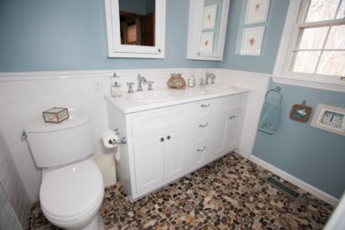 Stone flooring contrasts nicely with the white cabinetry 