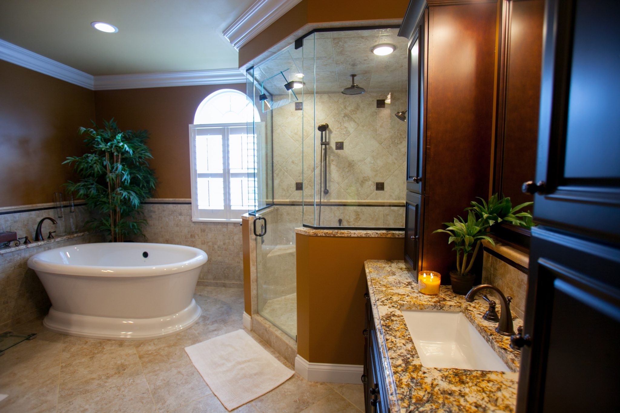 Beautiful steam shower with rain shower head and body sprayer with glass door enclosure.